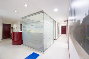 Area uffici medici dello studio dentistico Casali Fornaciari con uffici a vetrate e lunghi corridoi
